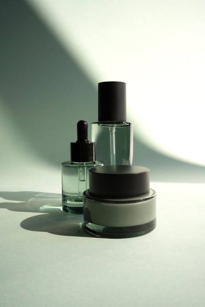 Sophisticated arrangement of cosmetic bottles casting elegant shadows on a white background.