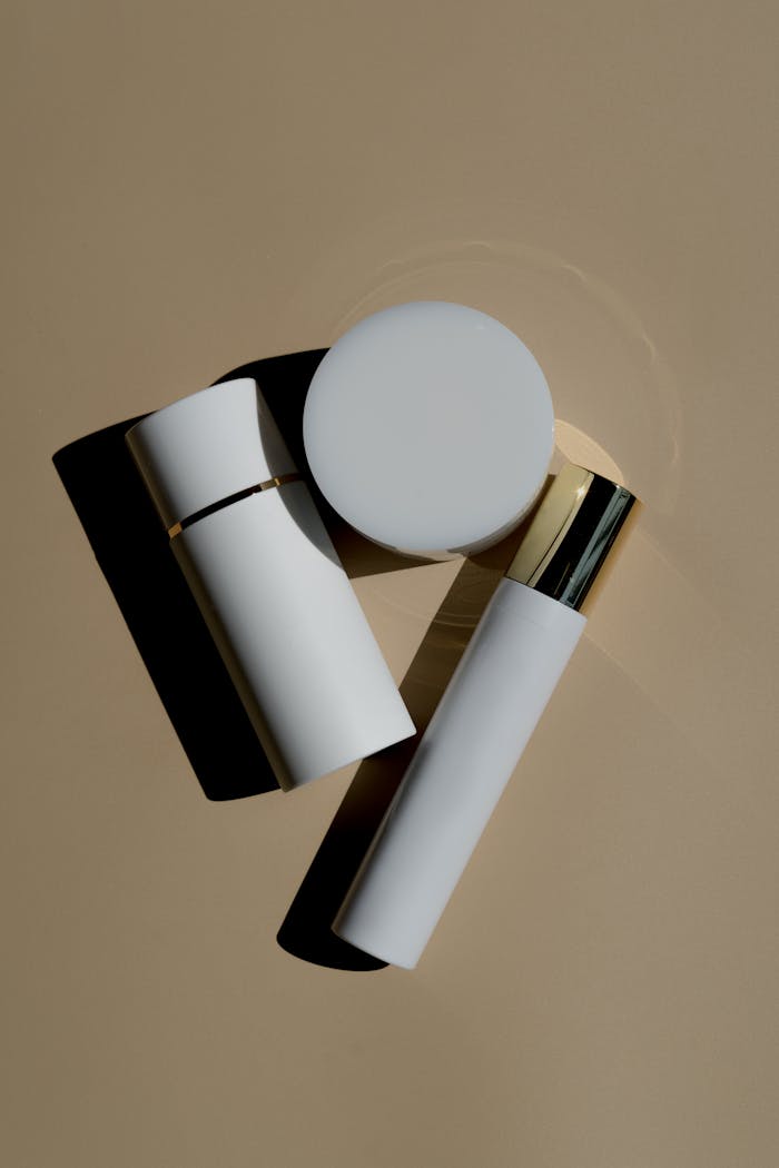 Minimalist flat lay of skincare products on beige background with shadows.